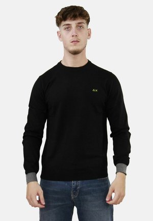 Maglione nero a maniche lunghe con collo rotondo, dettagli grigi ai polsini e un piccolo logo verde sul petto, realizzato in un tessuto morbido.