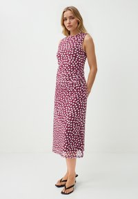 Mouwloze midi-jurk in bordeauxrood, met witte stippen, gerimpelde details bij de taille en een soepele, lichte stof.