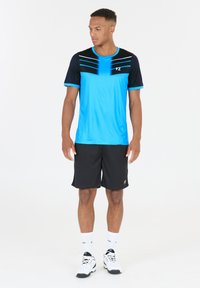 Blå och svart träningsklädset, bestående av en kortärmad tröja med ränder och logotyp, tillsammans med svarta shorts. Slätt tyg med mjuk textur.