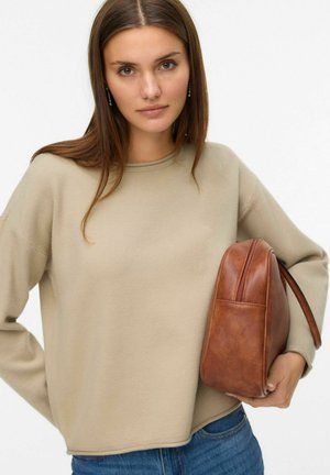 Felpa beige a maniche lunghe con collo rotondo, abbinata a una borsa a spalla in pelle marrone con chiusura a zip e finitura texturizzata.
