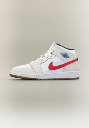 Λευκό sneaker Air Jordan με μεσαίο πάνω μέρος, κόκκινο σήμα Nike, μπλε λογότυπο Air Jordan, λευκά κορδόνια και καφέ σόλα, εμφανίζεται σε προφίλ.