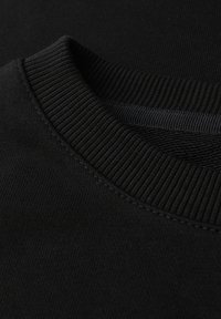 Sudadera negra con cuello redondo acanalado y textura de tela suave. Las costuras son visibles alrededor del escote.