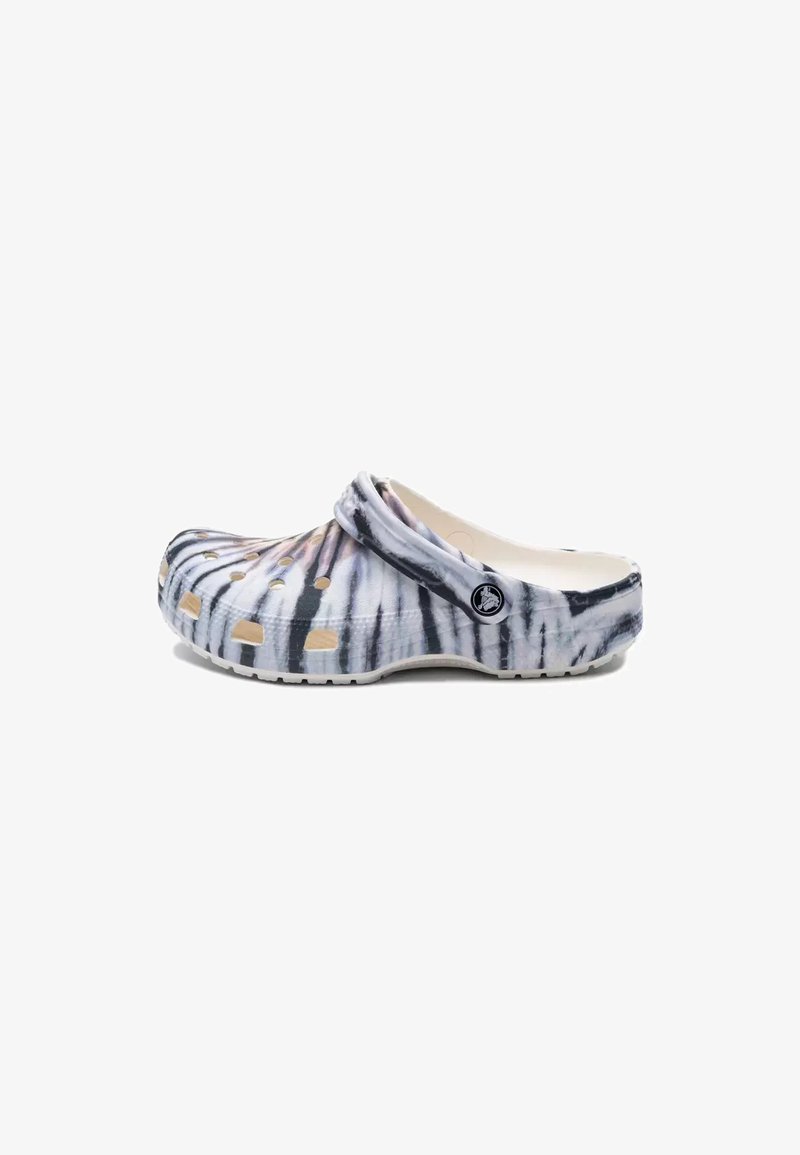 Sabot slip-on motif tie-dye noir et blanc avec trous de ventilation et bride de talon réglable, détail du logo latéral visible.