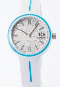 Hvid silikoneur med en rund sølvglitrende urskive, blå detaljer, sølvfarvede hænder og en krone af rustfrit stål. Har timemarkører og logo.