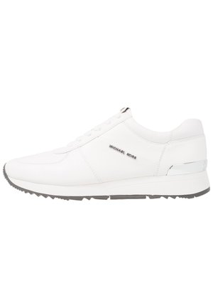 Sneaker din piele albă cu o textură netedă, talpă din cauciuc gri, șapte orificii pentru șireturi și un accent argintiu pe toc. Logo-ul este afișat pe lateral.