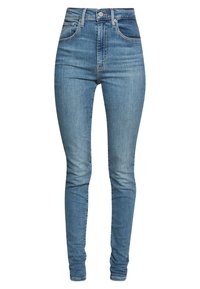 Jeans de mezclilla azul con cintura alta, corte slim y desvanecimiento mínimo. Cuenta con cinco bolsillos y cierre de botón y cremallera estándar.
