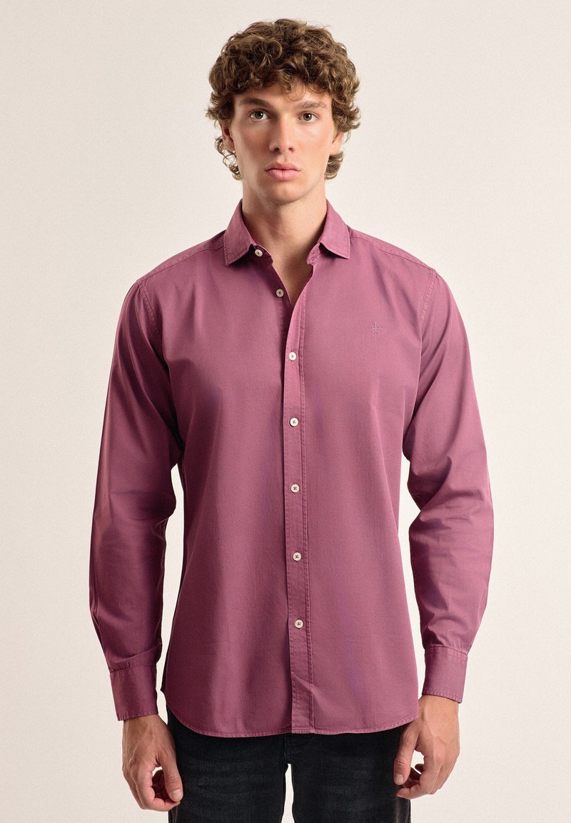 Camisa de manga larga, con botones, en un color malva apagado, confeccionada en una tela suave, que presenta un cuello estándar y un pequeño logotipo bordado en el pecho.