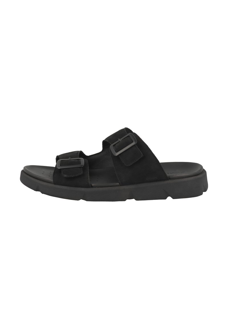 Svarta mockaskor i slip-in-modell med två justerbara spännen, platt gummisula och perforerat fotbädd för andningsförmåga.