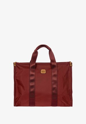 Sac fourre-tout en nylon rouge avec poignées en tissu doubles, de forme rectangulaire, et un patch logo en cuir marron sur le devant. Texture lisse.