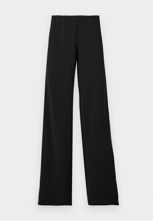 Pantalons larges noirs en tissu doux, avec une taille élastique et une texture lisse offrant une silhouette épurée.