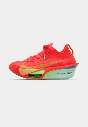 Scarpa da corsa rosso brillante con tomaia in flyknit, accenti gialli, suola verde e unità d'aria esposta. Design con lacci e punta rinforzata.