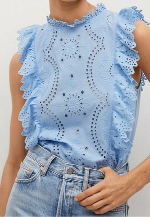 Lichtblauwe mouwloze blouse met ajourborduursel, gerimpelde schouders en een ronde hals; gecombineerd met high-waist denim shorts.