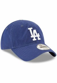 Modrá baseballová čiapka vyrobená z bavlny, s bielym vyšitým logom "LA" na prednej strane. Zakrivený šilt a nastaviteľný remienok na zadnej strane.