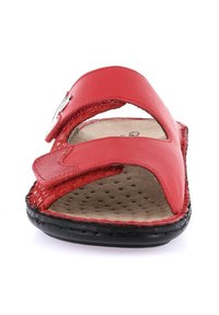 Sandal in pelle rossa con due cinturini regolabili, superficie texturizzata e soletta imbottita. Suola in gomma nera con una leggera curvatura.