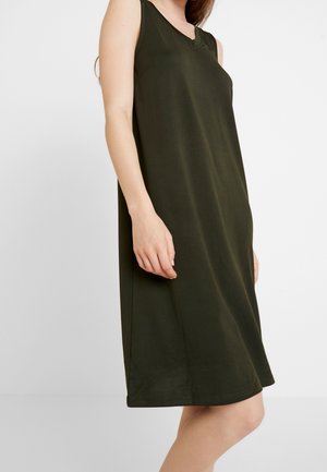 Niemająca rękawów oliwkowa sukienka z miękkiej bawełny, z dekoltem w kształcie litery V i subtelnymi bocznymi szwami, sięgająca tuż ponad kolano.