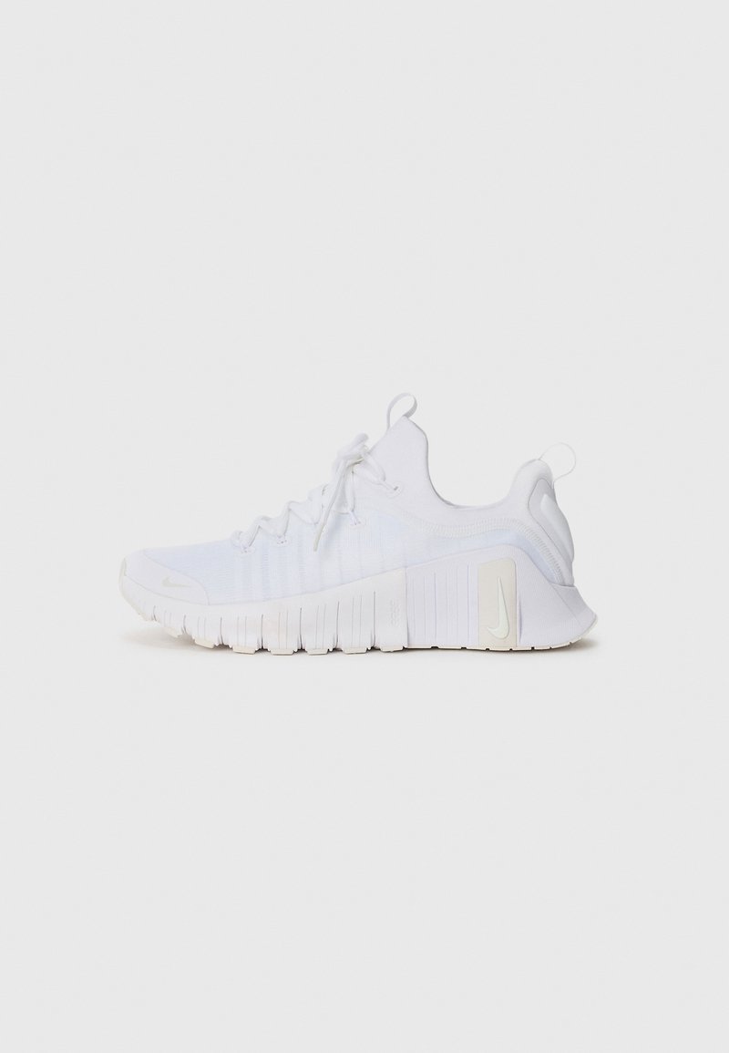 Baskets de sport blanches avec une tige en maille, semelle texturée et lacets. Présente un logo discret sur le côté et un talon rembourré pour un soutien optimal.
