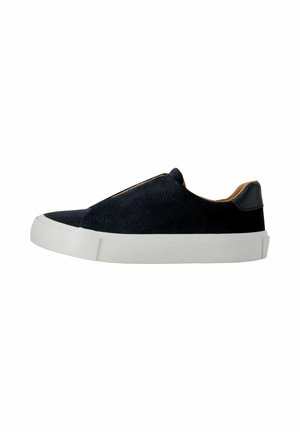 Sort slip-on sneaker med hvid gummisål og tan indvendig foring, sidevisning på hvid baggrund.