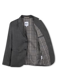 Blazer grigio con due bottoni frontali e una tasca; l'interno presenta un motivo a scacchi in bianco e nero. Il materiale ha una texture liscia.