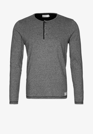 Grijze lange mouw henley-shirt gemaakt van een zachte stof. Heeft drie zwarte knopen en contrasterende zwarte accenten bij de halslijn en de zoom.