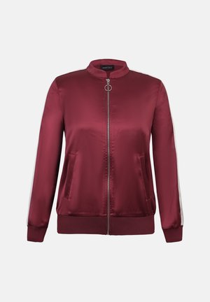 Μπουφάν bomber σε βουργουνδί χρώμα από σατέν, με φερμουάρ μπροστά, γιακά όρθιο, πλαϊνές τσέπες και αντίθετες λευκές ρίγες στα μανίκια.