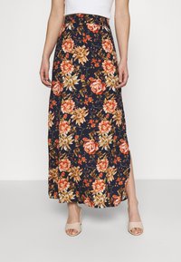 Jupe longue florale avec un fond bleu marine orné de fleurs rouges et dorées, taille élastique, et fente latérale pour un détail supplémentaire.