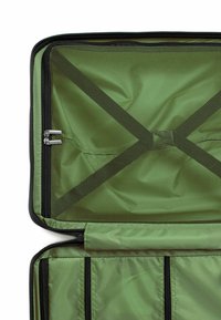 Zelený interiér zavazadla s hladkým textilním povrchem, síťovými oddíly a černými zipovými okraji. Vybaveno křížovými popruhy pro zajištění věcí.