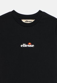 Camiseta negra de algodón con cuello redondo y mangas cortas, que presenta un logo blanco de "ellesse" y un acento geométrico en rojo y naranja.