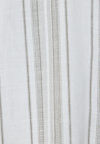 Tejido a rayas con una superficie texturizada, con líneas verticales alternas en blanco y marrón claro. Material suave y ligero.