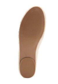Semelle d'une chaussure brun clair avec une prise ovale en relief sur l'avant et un talon circulaire en relief, le tout sur un fond blanc.
