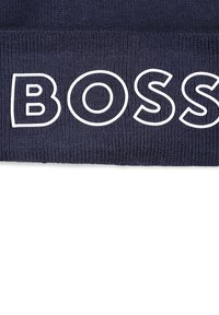 Bonnet tricoté navy avec un logo "BOSS" blanc et audacieux affiché en évidence sur le devant, doté d'un tissu texturé et d'un ajustement confortable.