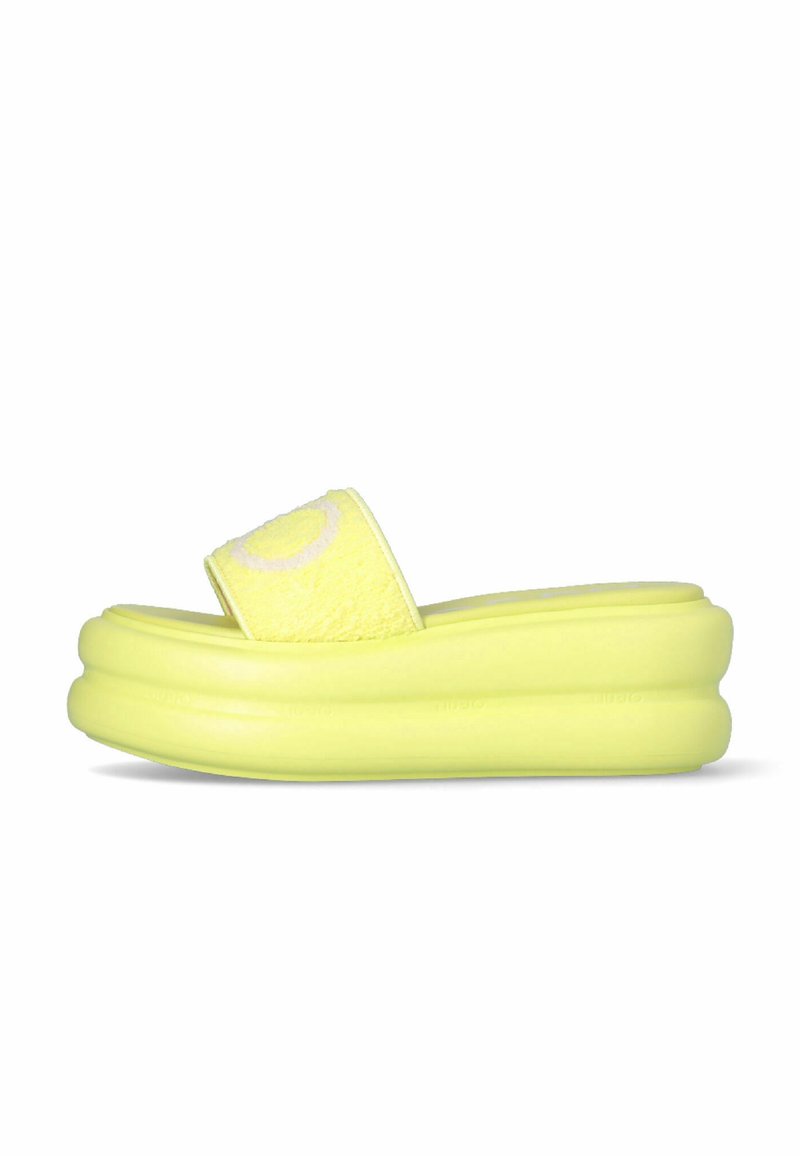 Sandale plateforme jaune à enfiler avec large bride texturée et semelle épaisse rembourrée, vue latérale sur fond blanc.