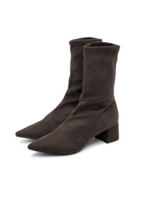Stivali alla caviglia in suede marrone con punta affusolata e tacco a blocco. Il design presenta una texture liscia e dettagli di cucitura minimi.
