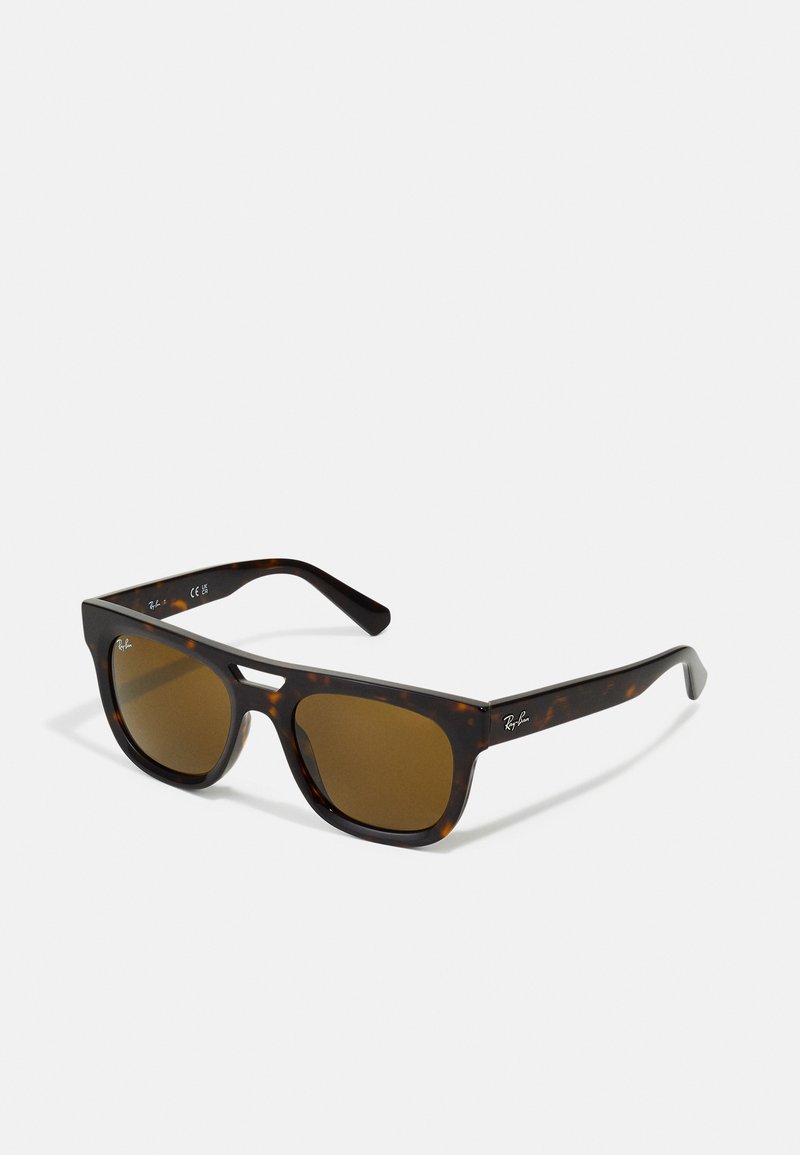 Óculos de sol tartaruga com lentes castanhas, design quadrado e estrutura de plástico resistente. Apresenta detalhe discreto do logótipo na lateral.