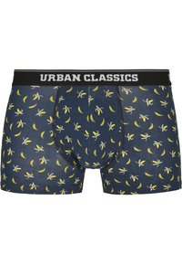 Marineblaue Boxershorts mit einem sich wiederholenden Bananenmuster, ausgestattet mit einem schwarzen elastischen Bund, auf dem "URBAN CLASSICS" in Weiß gedruckt ist.