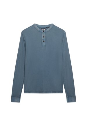 Blauw henley-shirt met lange mouwen, drie donkere knopen op de voorplacket en een ronde halslijn.