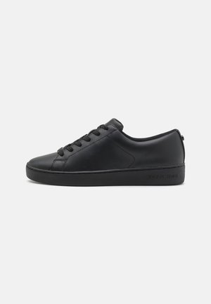 Must musta sneaker, millel on sile pind, ümar varvas, lame tald ja kuus aasaga paelad. Omab brändi logo kandadel.