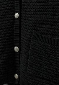 Črn kardigan z teksturo, ki ima rebrast ovratnik in manšete, pet kovinskih gumbov in sprednji žep z tkano zasnovo.