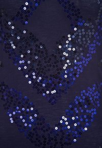 Tessuto blu navy decorato con un motivo di paillettes sovrapposte in tonalità di blu, nero e argento metallico, creando una superficie texturizzata.