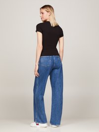 Black fitted t-shirt with short sleeves, paired with high-waisted blue wide-leg jeans and white sneakers. Simple design, no patterns.