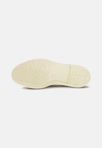 Gumi talp off-white színben, struktúrált tapadási mintával. Simább éllel és márkázott területtel rendelkezik a sarok közelében. Különböző lábbelikhez alkalmas.