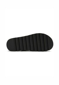 Black rubber shoe sole with horizontal ridges for traction. Rounded toe and slight curve at the heel, featuring a smooth, matte texture.