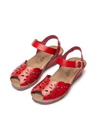 Red leather wedge sandals with cut-out floral designs, adjustable ankle strap, and textured footbed. Lightweight with a low heel.