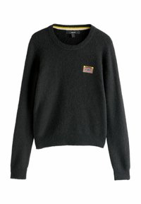 Pull noir en matériau pelucheux, avec un col rond, des manches longues et un patch coloré représentant une cassette sur le devant.