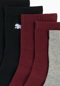 Kariowane skarpetki bawełniane w kolorach czarnym, burgundowym i szarym, z białym logo na czarnej parze. Każda skarpetka ma jednolity kolor i zróżnicowaną teksturę.