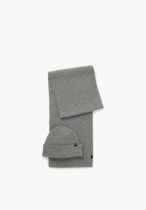 Set composto da sciarpa e berretto in maglia grigia a coste. La sciarpa è lunga e rettangolare, mentre il berretto è arrotondato con risvolto. Presenta una texture sottile.