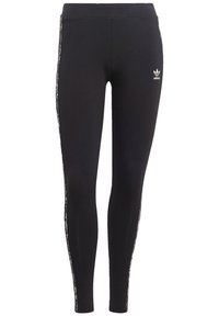 Svarta Adidas leggings med vitt trefoil-logotyp på överbenet och leopardmönstrade ränder som löper längs med utsidan av benen.