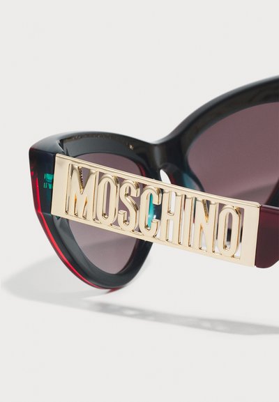 Svarta och burgundy solglasögon med mörka linser, prydda med en guld Moschino-logotyp på framsidan. Slät textur med djärva designelement.