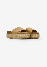 Sandales à plateforme en suède beige avec une large sangle croisée, dotées d'une semelle en corde de jute et d'une semelle en caoutchouc pour une meilleure traction.