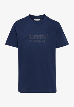 To børn står side om side iført matchende mørkeblå hummel sportst-shirts og bukser mod en ensfarvet baggrund.
