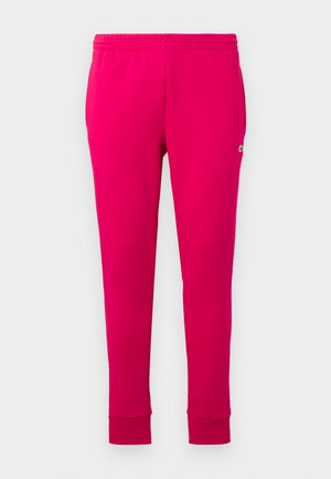 Pantalons de jogging fuchsia avec taille élastique, coupe fuselée et un petit logo sur le côté. Fabriqués en tissu doux et lisse.